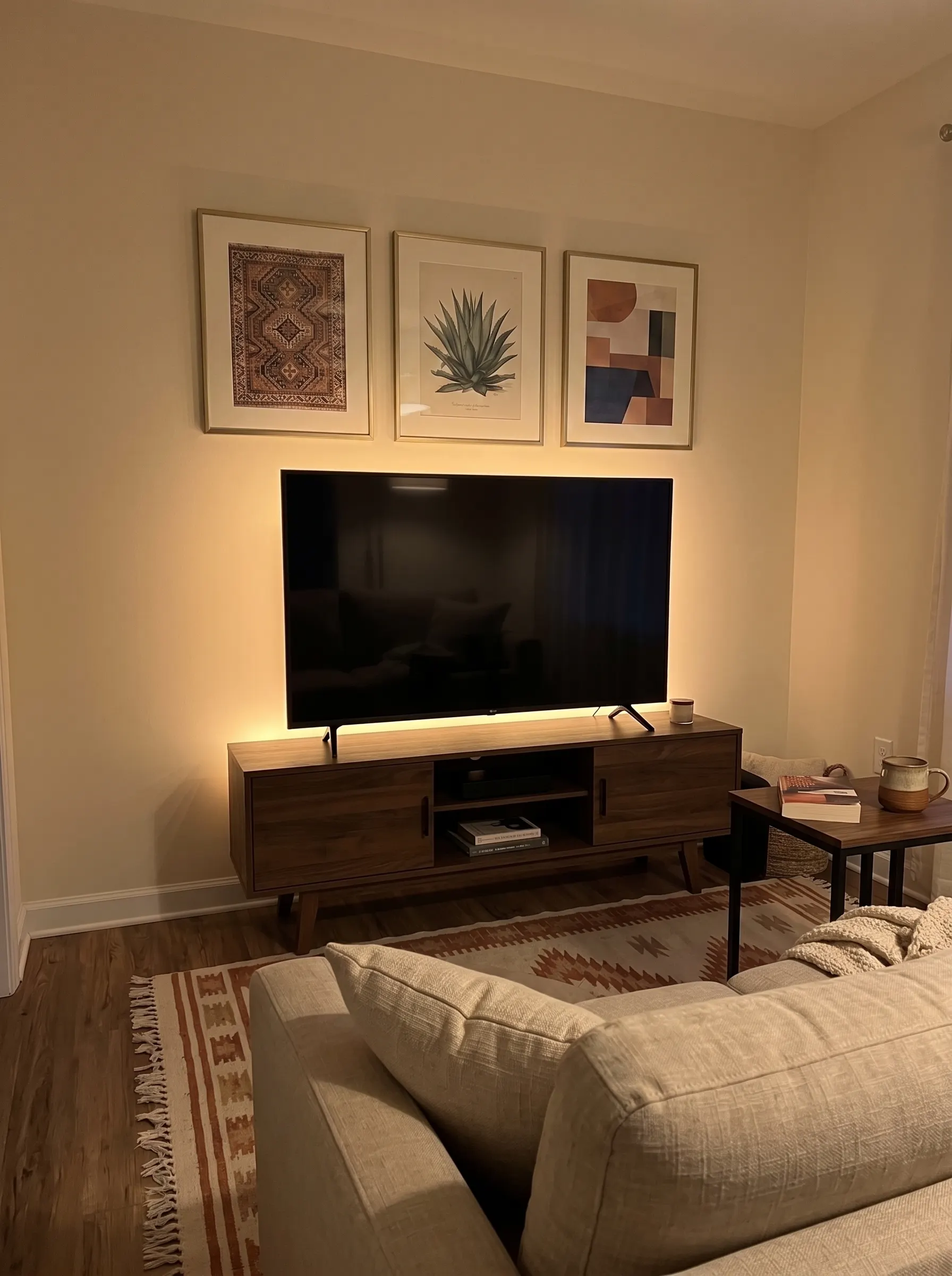 Warm COB LED strip light hidden behind a TV unit casting a soft amber glow on the wall of a college apartment, a simple college apartment must have for cozy ambience